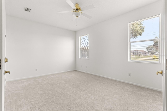 carpeted empty room featuring ceiling fan and a healthy amount of sunlight