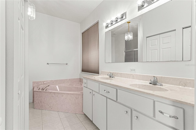 bathroom featuring a bath to relax in, tile floors, and double vanity