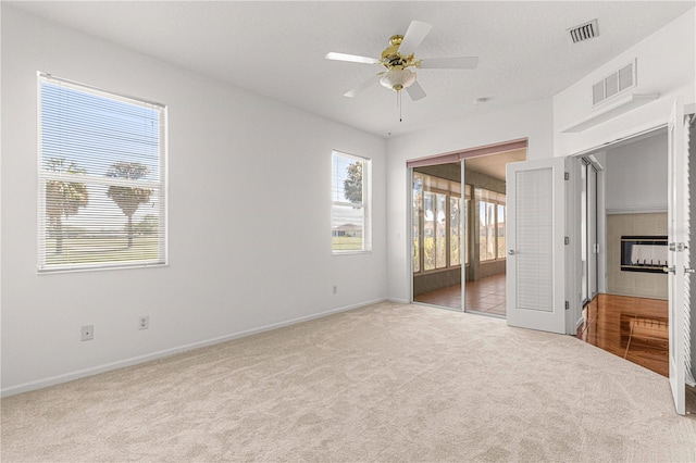 unfurnished bedroom featuring light colored carpet, a closet, ceiling fan, and multiple windows