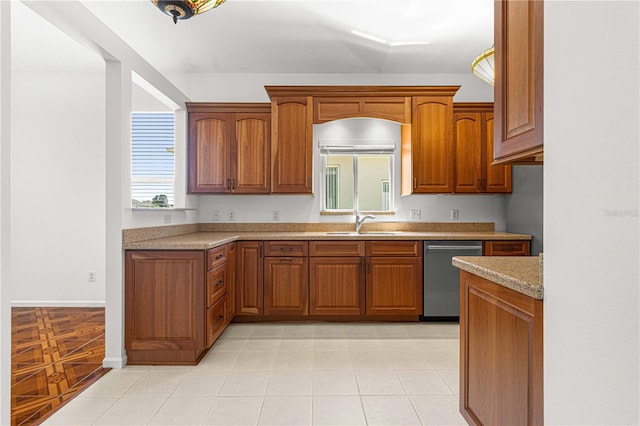 kitchen featuring sink, dishwasher, light stone countertops, and light tile floors