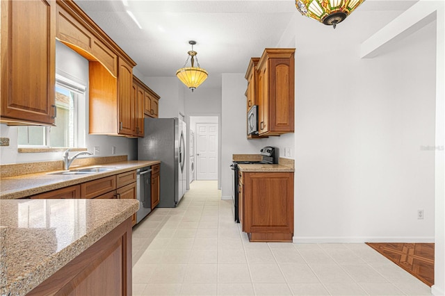 kitchen featuring light tile floors, stainless steel appliances, sink, light stone countertops, and hanging light fixtures