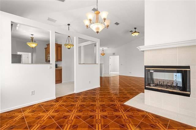 unfurnished living room featuring a tiled fireplace, an inviting chandelier, and dark tile flooring