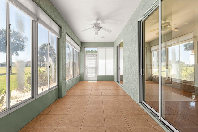 unfurnished sunroom featuring ceiling fan