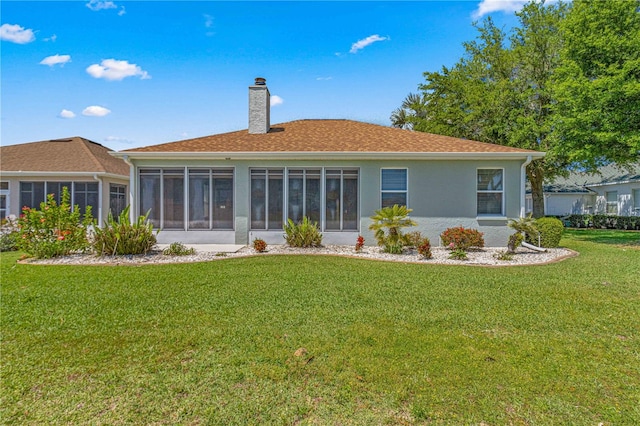 back of house featuring a lawn and a sunroom