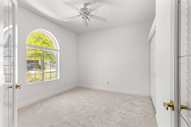 carpeted spare room featuring vaulted ceiling, a textured ceiling, ceiling fan, and plenty of natural light