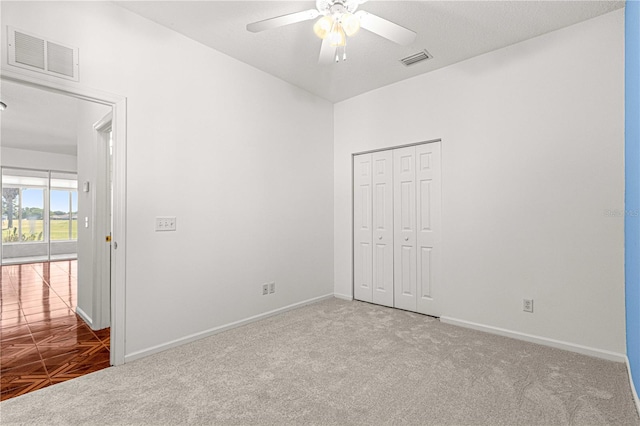 carpeted spare room featuring ceiling fan