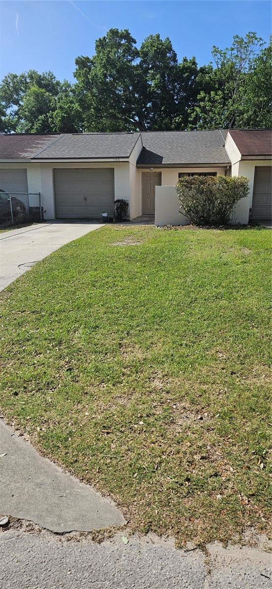 single story home with a garage and a front yard