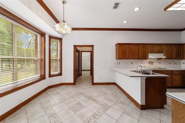 kitchen featuring hanging light fixtures, backsplash, light tile patterned floors, ornamental molding, and a notable chandelier