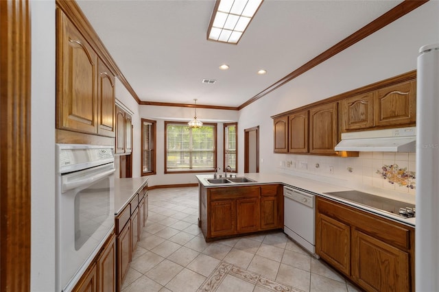 kitchen featuring sink, kitchen peninsula, white appliances, decorative light fixtures, and decorative backsplash