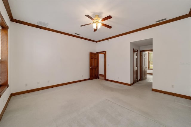 unfurnished room featuring ornamental molding, ceiling fan, and light colored carpet