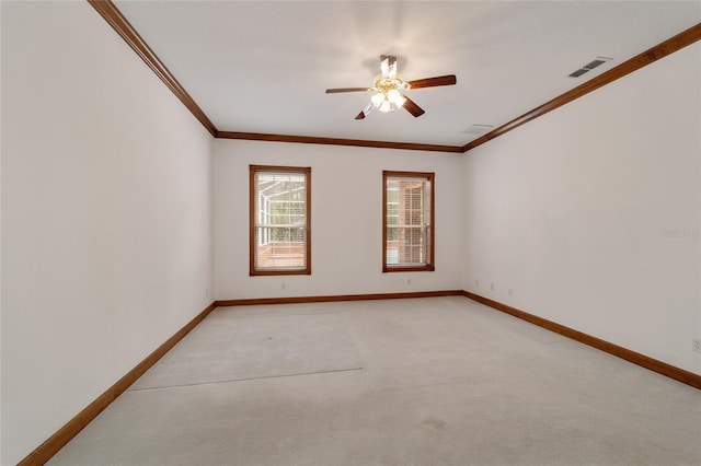 carpeted spare room featuring ceiling fan and crown molding