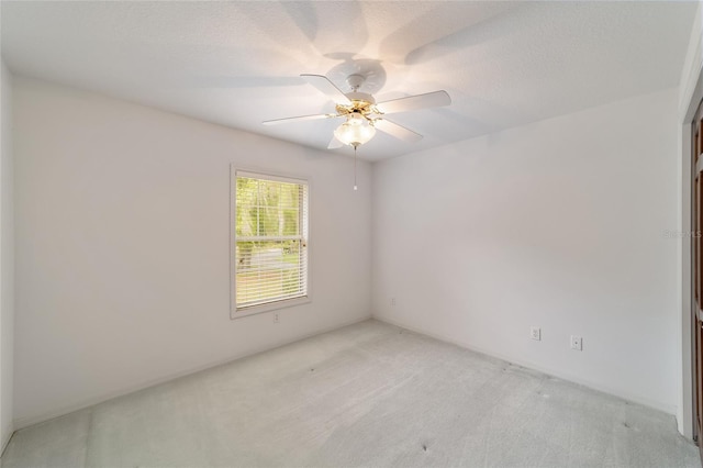 carpeted empty room featuring ceiling fan and a textured ceiling