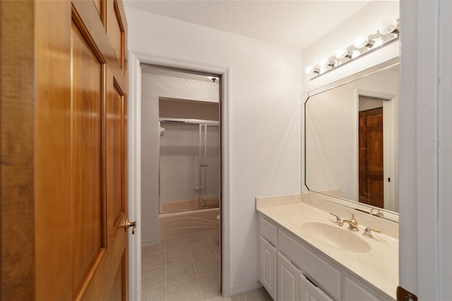 bathroom featuring tile patterned floors, a textured ceiling, vanity, and bath / shower combo with glass door