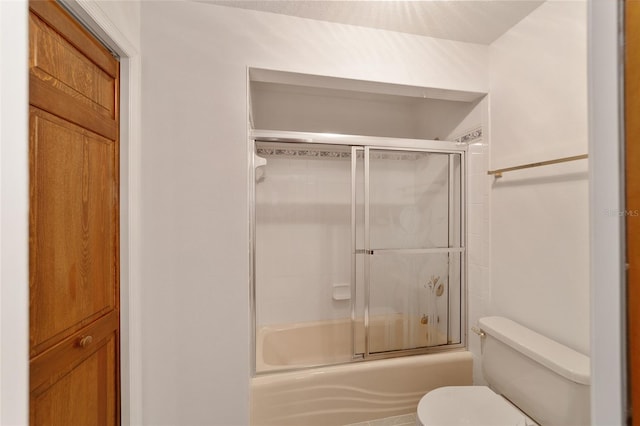 bathroom with bath / shower combo with glass door and toilet