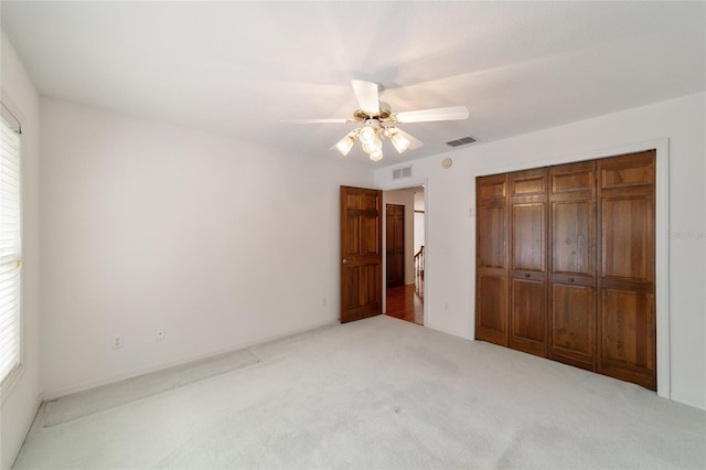 unfurnished bedroom featuring multiple windows, ceiling fan, and a closet