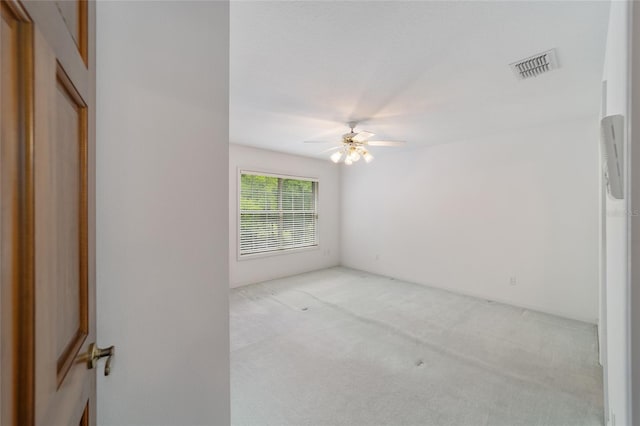 carpeted spare room featuring ceiling fan