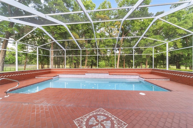 view of pool featuring glass enclosure and a patio area