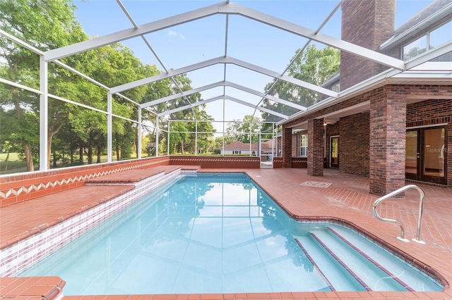 view of pool featuring glass enclosure and a patio area