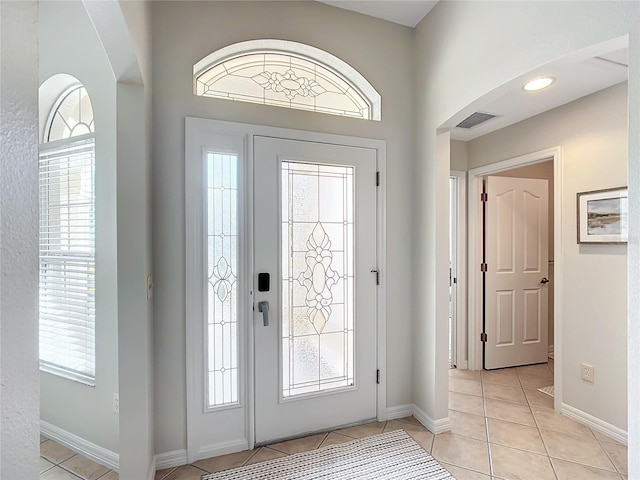 foyer entrance with light tile patterned floors and a wealth of natural light