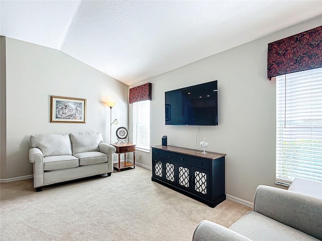 carpeted living room featuring vaulted ceiling