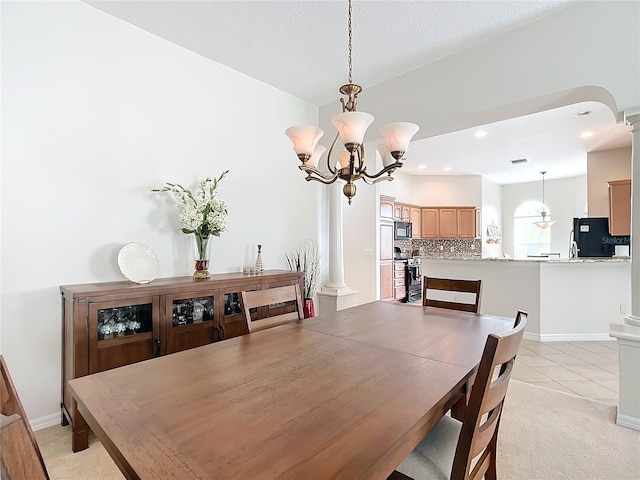 dining area featuring decorative columns, light tile patterned floors, and a notable chandelier