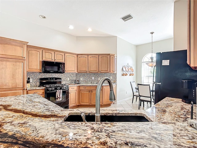 kitchen featuring light stone countertops, sink, decorative light fixtures, light tile patterned floors, and black appliances