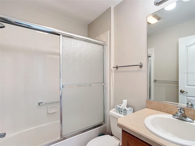 full bathroom featuring vanity, enclosed tub / shower combo, and toilet