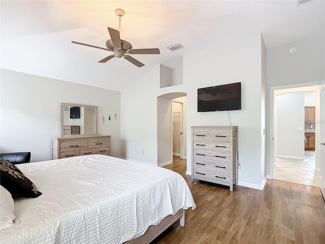 bedroom with hardwood / wood-style flooring, ceiling fan, and high vaulted ceiling