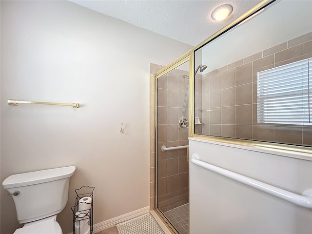 bathroom featuring tile patterned flooring, toilet, and a shower with door