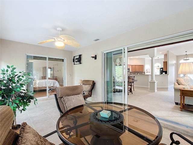 tiled living room featuring ornate columns and ceiling fan