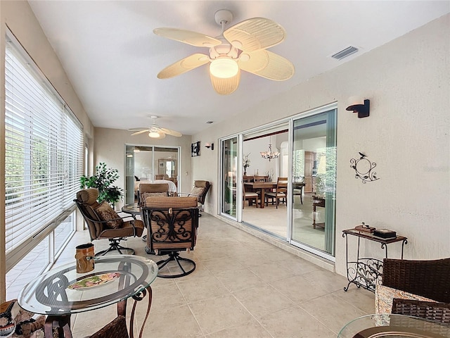 sunroom with ceiling fan with notable chandelier