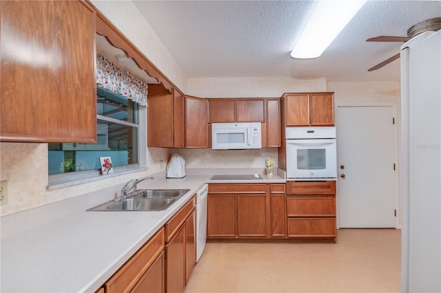 kitchen with ceiling fan, white appliances, a textured ceiling, and sink