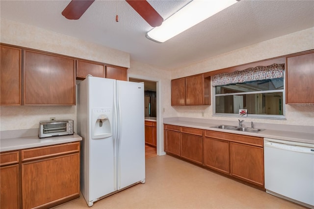 kitchen with ceiling fan, white appliances, sink, and a textured ceiling