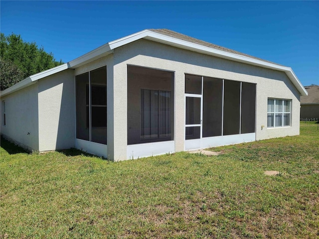 view of side of home with a yard and a sunroom