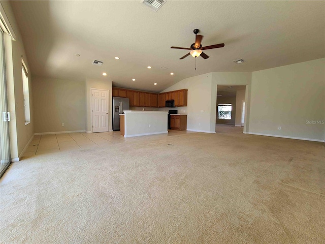 unfurnished living room with lofted ceiling, light carpet, and ceiling fan