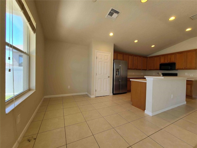 kitchen with stainless steel fridge with ice dispenser, a kitchen island with sink, light tile floors, and lofted ceiling