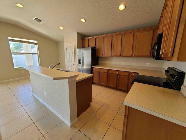 kitchen featuring range with electric stovetop, stainless steel fridge with ice dispenser, a center island with sink, lofted ceiling, and sink