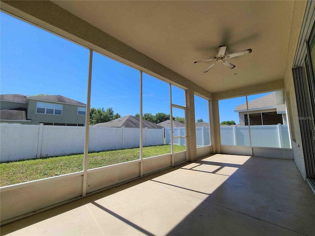 unfurnished sunroom featuring ceiling fan