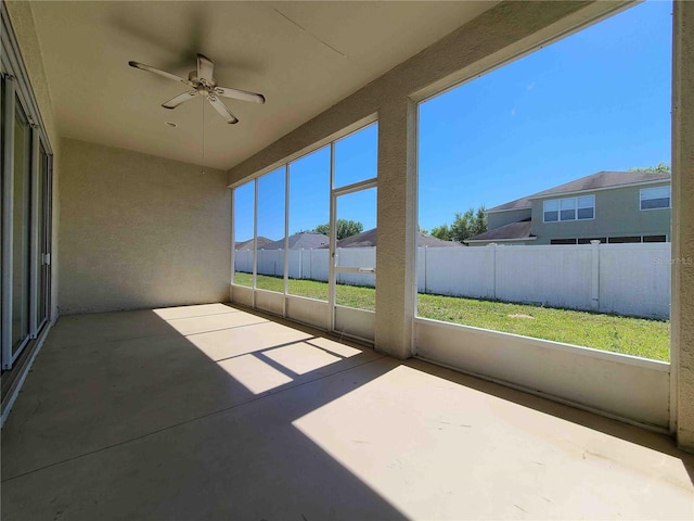 unfurnished sunroom with ceiling fan