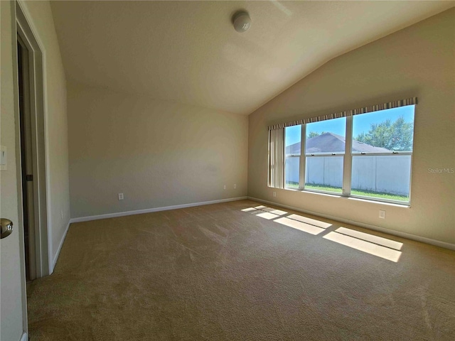 carpeted empty room featuring lofted ceiling