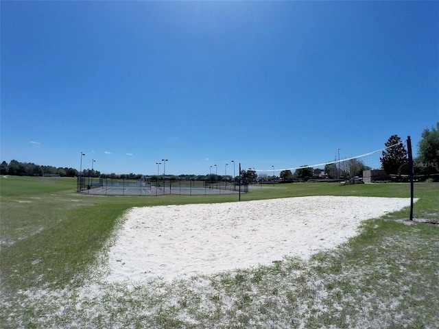 view of home's community featuring volleyball court and a lawn