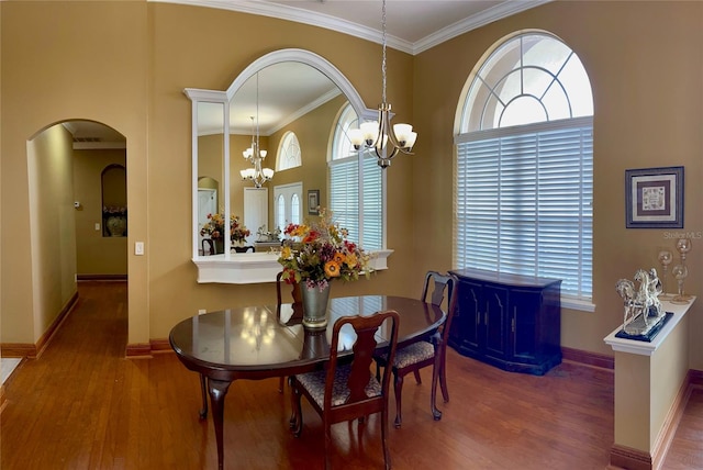 dining space with an inviting chandelier, ornamental molding, and dark wood-type flooring