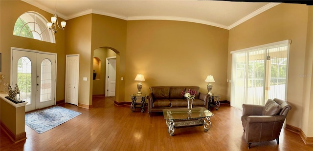 entryway featuring an inviting chandelier, a healthy amount of sunlight, crown molding, and dark hardwood / wood-style flooring