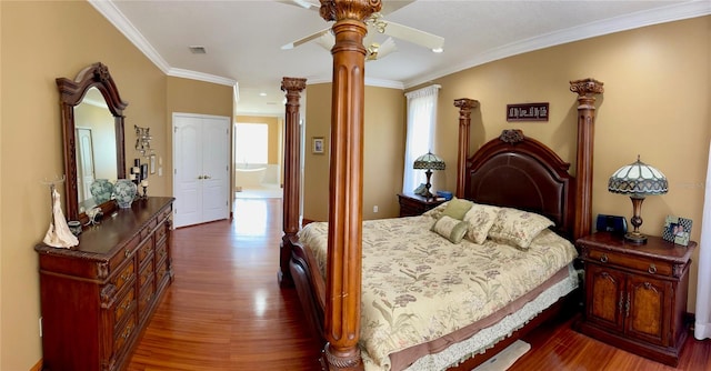 bedroom featuring ceiling fan, decorative columns, ornamental molding, and dark hardwood / wood-style floors