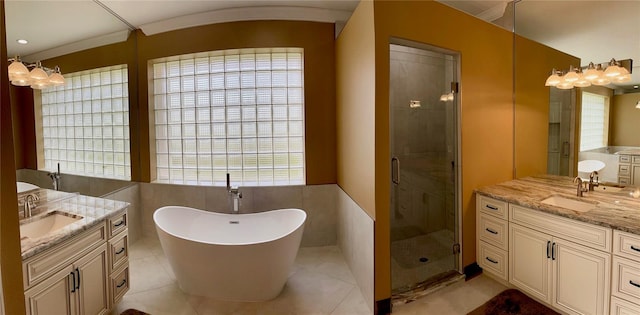 bathroom featuring tile flooring, plus walk in shower, tile walls, and dual bowl vanity