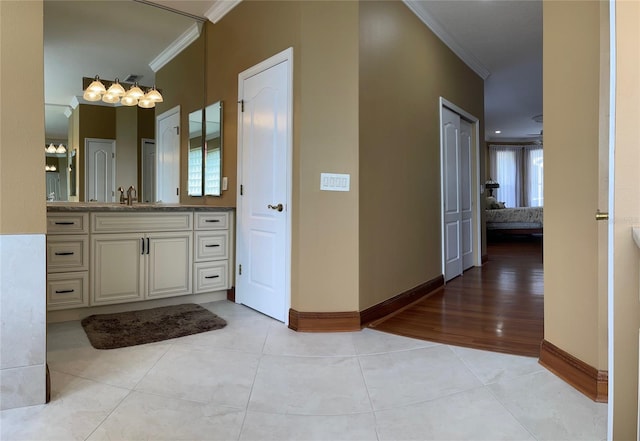 bathroom featuring ornamental molding, hardwood / wood-style floors, oversized vanity, and a healthy amount of sunlight