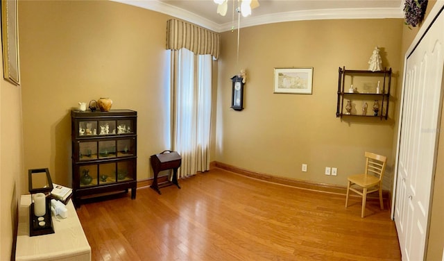 sitting room with ceiling fan, ornamental molding, and light hardwood / wood-style floors