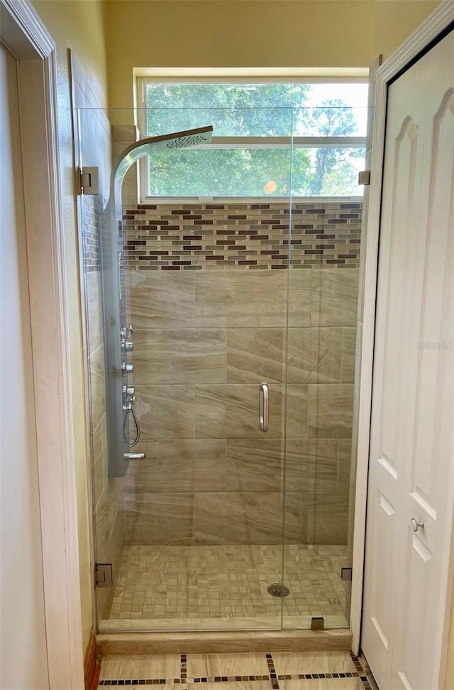 bathroom with a shower with door