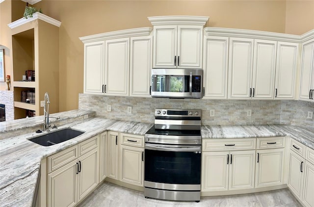 kitchen with appliances with stainless steel finishes, light stone counters, tasteful backsplash, and sink