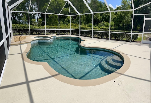 view of pool featuring glass enclosure, an in ground hot tub, and a patio